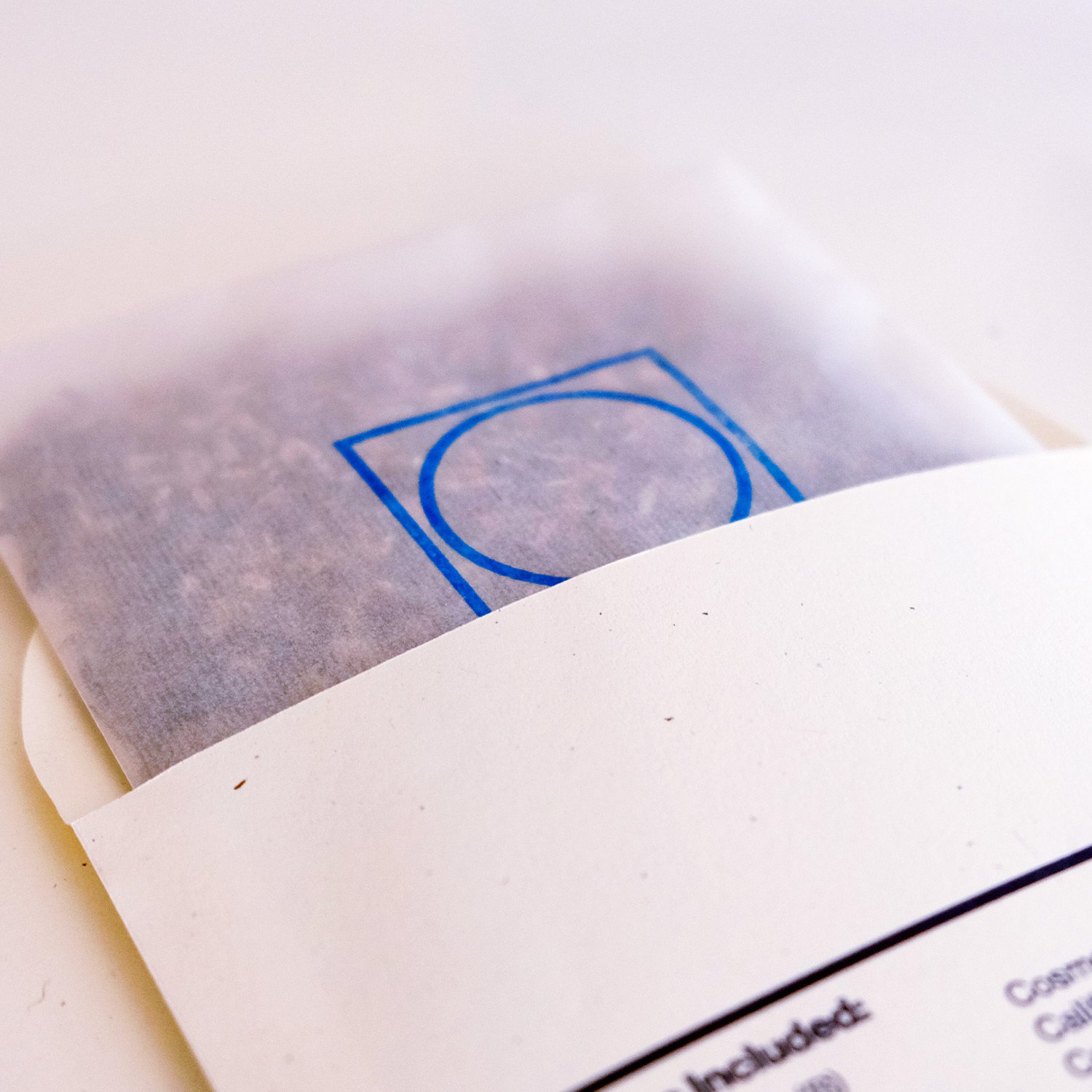 A shot of a seed pack half open with a blue logo stamped on it