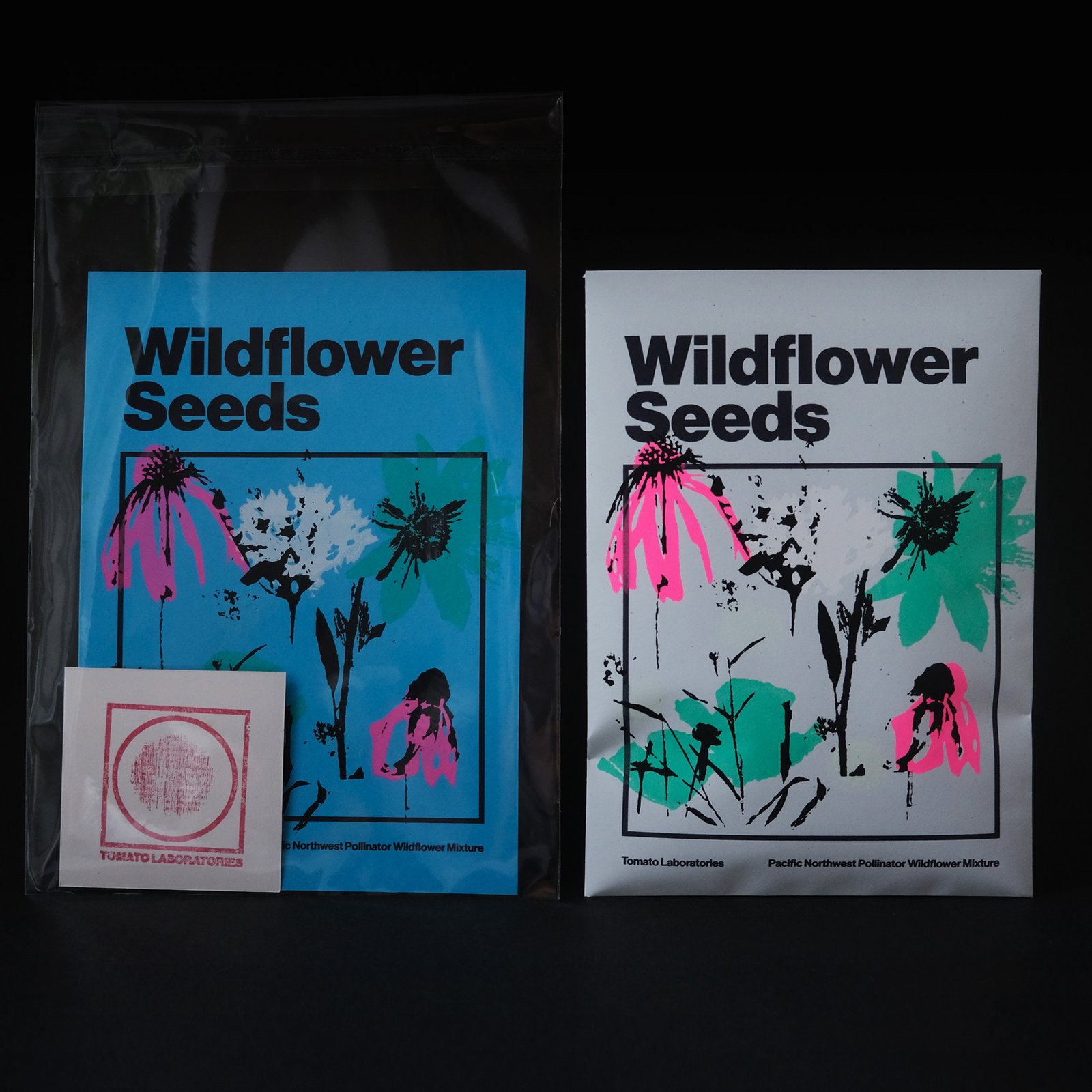 A cornflower blue, vibrant flower print is seen next to a similar print on light colored seed pack paper - pinks, greens, and glow colors on black background