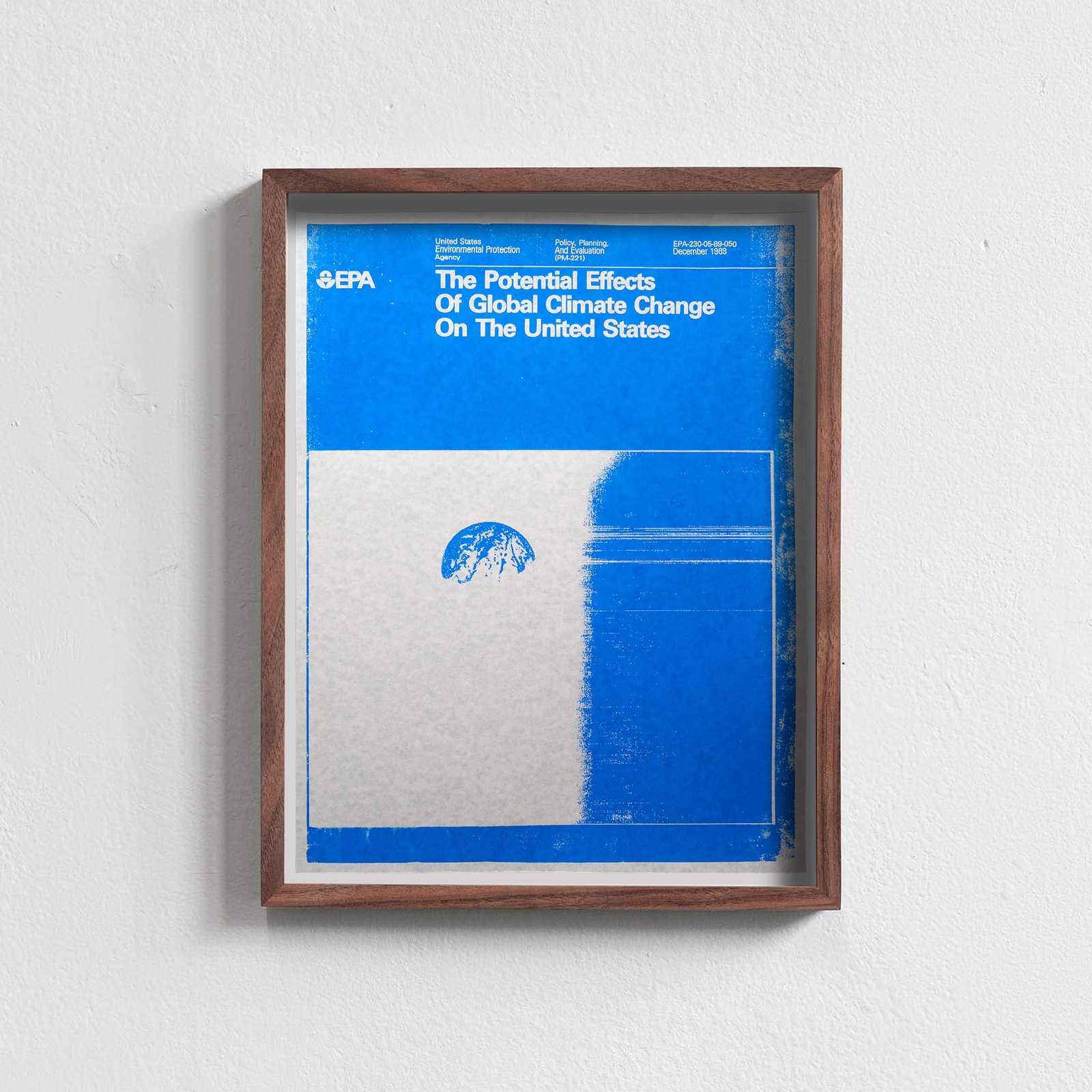 A photo of a framed vintage EPA poster from 1989 titled The Potential Effects of Global Climate Change on the United States, blue on blue paper, with a blue Earth